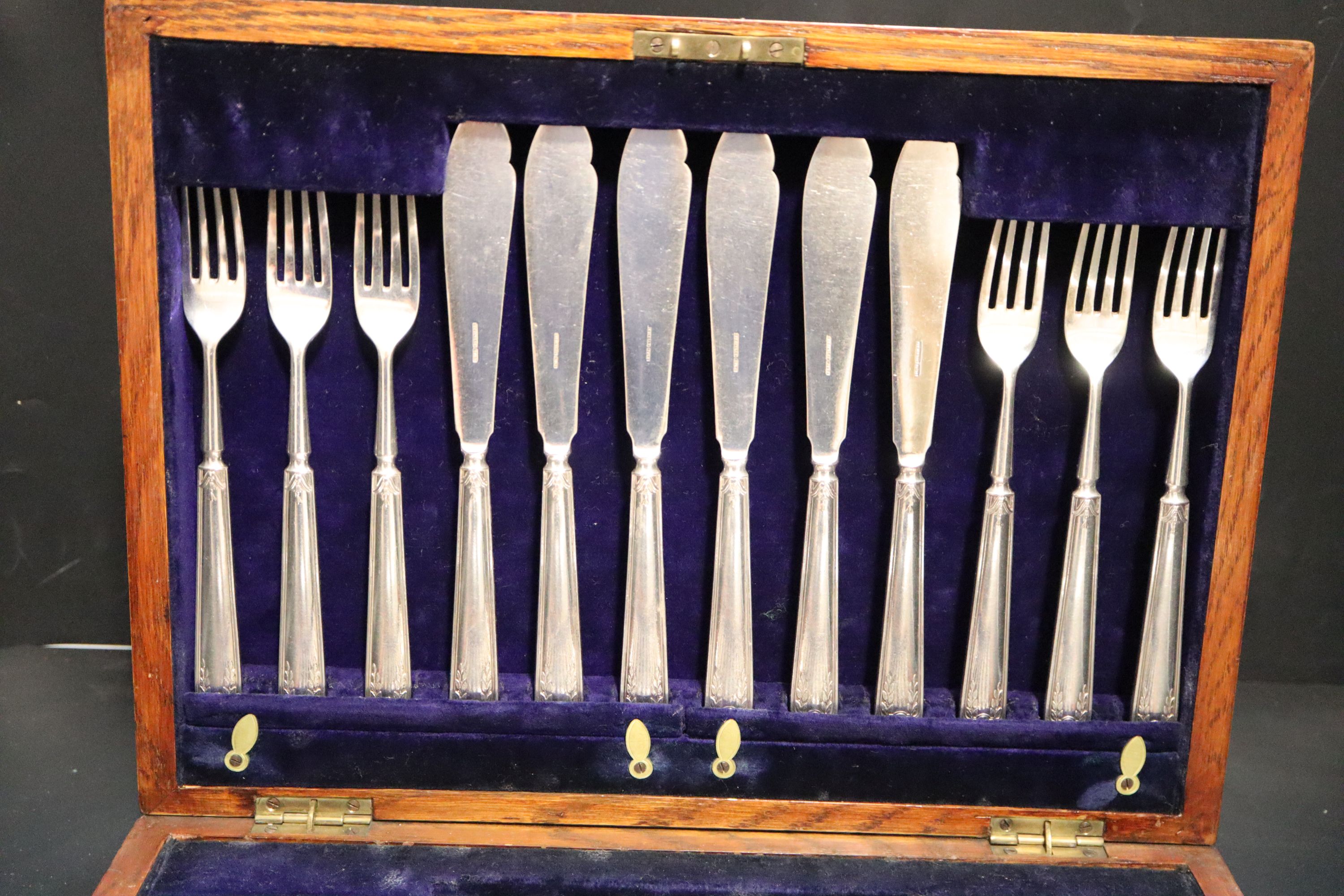 An oak cased set of twelve pairs of Elkington & Co silver plated fish knives and forks,